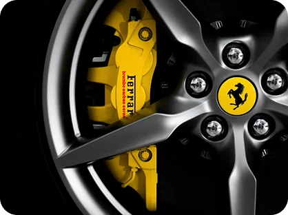 Luxury Ferrari sports car wheel with yellow brake caliper and premium alloy rim detail